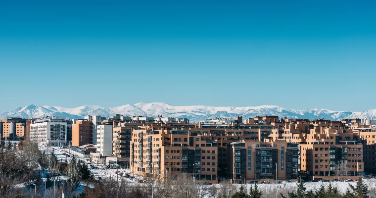 Bloques de viviendas de un barrio residencial con la sierra nevada al fondo en una mañana de invierno